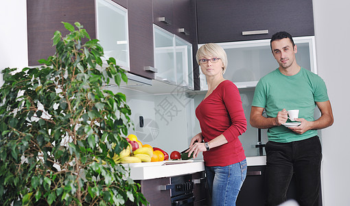 年轻夫妇在现代厨房玩得开心沙拉幸福房子烹饪妻子女士白色丈夫食物蔬菜图片