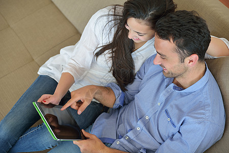 家庭夫妇使用平板电脑女士阅读女朋友网络笔记本丈夫恋人闲暇男人房子图片