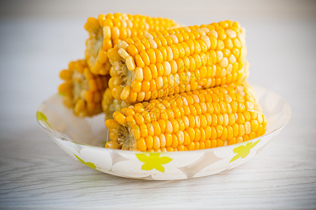 盘子上几头煮熟的玉米桌子粮食美食小吃蔬菜农业烹饪饮食玉米芯金子图片