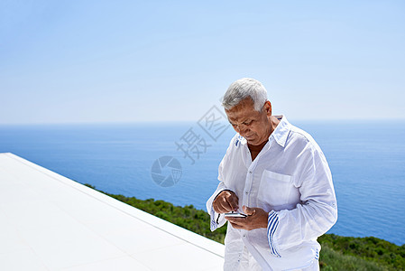 使用智能电话的高级男子手机老年人头发自拍微笑细胞快乐男人海洋技术图片