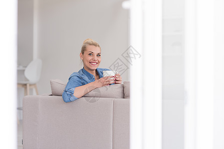 女人喜欢喝一杯咖啡女性闲暇长椅女士幸福房间女孩杯子微笑香气图片