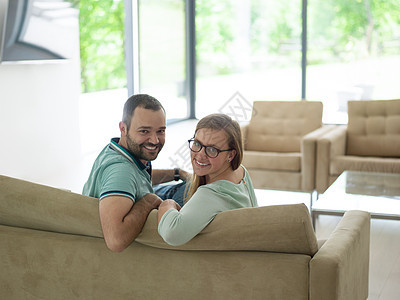 看着一对夫妇看电视的近视沙发房子婴儿男人成人屏幕水平中年女性闲暇图片