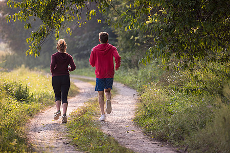 在乡村公路上慢跑的年轻夫妇运动男性夫妻训练自由活力阳光运动装运动员活动图片