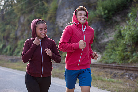 在乡村公路上慢跑的年轻夫妇农村运动员冒险阳光女孩女性自由活力跑步活动图片