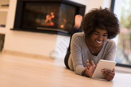 在地板上使用平板电脑的黑人黑人妇女微笑女性思考女孩女士黑色头发奢华冲浪壁炉图片