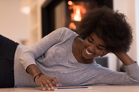 在地板上使用平板电脑的黑人黑人妇女头发女孩微笑壁炉成人地面女士互联网奢华黑色图片