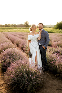 在熏衣草地上的新娘和新郎植物地面蓝色场地裙子夫妻婚礼女孩白色日落背景图片