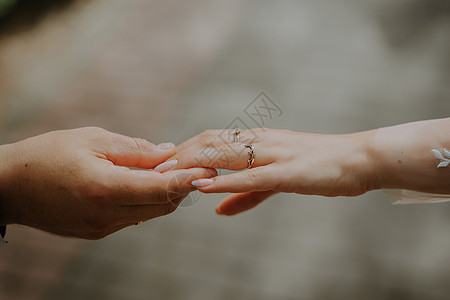 新婚夫妇在日落时手牵着手 结婚戒指 男人给他的女朋友订婚戒指图片