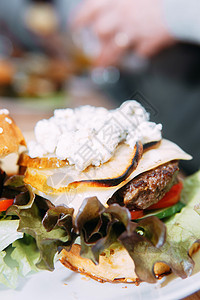 有牛肉和蔬菜的汉堡 烹饪班上好吃的汉堡 洋葱酱的汉堡午餐餐厅盘子桌子面包芝麻洋葱美食炙烤包子图片