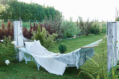 村屋院子里的街道上有一张带枕头和毯子的吊床 在该国放松的地方 夏天的概念 去乡下旅行图片