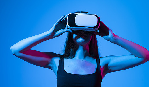 现代 VR 眼镜中令人惊讶的女性在拥有虚拟现实体验的同时与网络互动 未来的技术概念 元宇宙图片