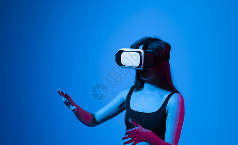 微笑的快乐女人用虚拟现实的Vr headset镜片体验到许多灰色背景的手 女孩花在逆向中的时间眼镜游戏工作室电脑技术娱乐女性工具图片