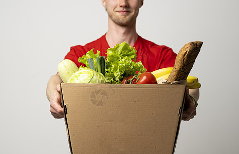 穿红色制服的男雇员携带纸纸箱包和杂货 产品从商店或餐馆运到家里 复制空间 (单位 千分之一)图片