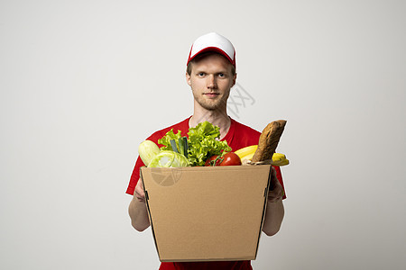 杂货店送货员身着红色T恤 在家给顾客送食物 食品交付服务 请访问InfoFinland上的图片