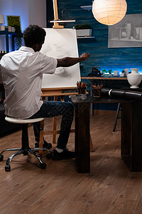 男人画家坐在画布前面画花瓶图片