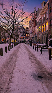 日落时 荷兰冬季的雪季阿姆斯特丹水平风光省会运输历史风景低温船屋首都红灯区图片