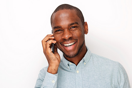 年轻黑人在孤立的白色背景下与手机交谈时紧紧地笑着微笑图片