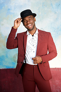 英俊的年轻黑人男子笑着带着帽子和旧礼服图片