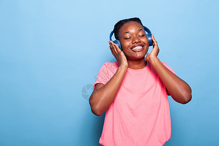 仅用耳机跳舞听音乐的非裔美国少年人图片