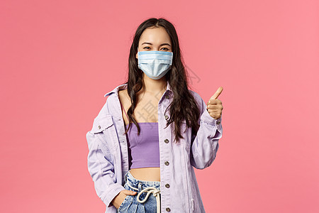 Covid19 隔离 人的概念 快乐的年轻女孩在站在医疗面罩和照相机面前时展示了拇指 鼓励在冠状病毒爆发期间保持安全女性疫苗疾病图片