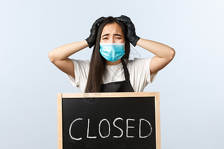 小型企业 covid-19 流行病 预防病毒和员工概念 戴着医用口罩的咖啡店老板在生意关门时惊慌失措 站在特写的标志附近图片