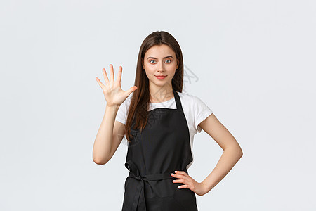 杂货店员工 小型企业和咖啡店的概念 穿着黑色围裙的快乐的年轻女咖啡师展示了五号 微笑着坚定 在咖啡馆工作图片