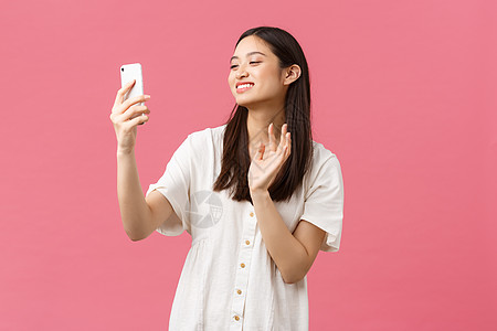 美 人的情感和技术概念 快乐美丽的亚洲女孩在视频聊天中与朋友聊天 对着智能手机摄像头挥手致意 作为录制视频信息 微笑着开朗图片