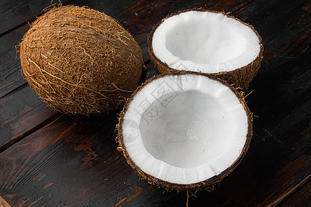 半块的椰子 在旧黑木桌背景上图片