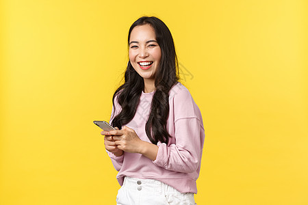 人们的情感 生活方式的休闲和美容理念 笑得开朗 快乐的亚洲女人 拿着智能手机 在阅读社交媒体应用上的搞笑帖子后 对着镜头大笑图片