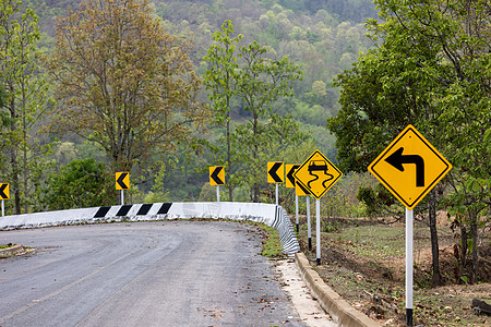 路牌示警警告指示左转弯 山上有滑滑道路的危险图片
