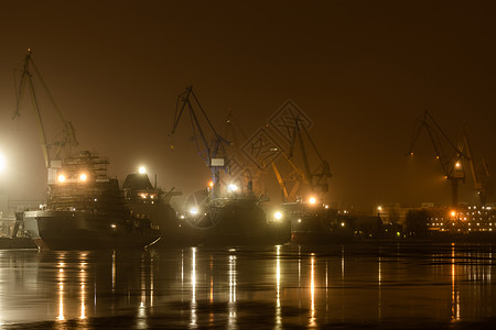 夜间建造核破冰器 冬季寒冷的波罗的海造船厂起重机 Neva河上蒸汽 河流平滑地表 雾雾港口技术商业船厂霜天出口城市码头镜子货运图片