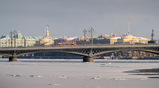 冬季城市圣彼得堡 结冰的涅瓦河 桥上的红色旅游巴士 冬宫 海军部大楼 亚历山大柱的全景图片