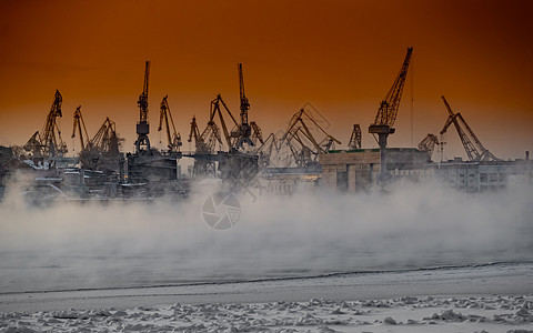 神奇日落时建造核破冰船 寒冷冬日波罗的海造船厂的起重机 涅瓦河上的蒸汽 光滑的河面 橙色的天空血管送货渔船码头建设出口商业后勤船图片