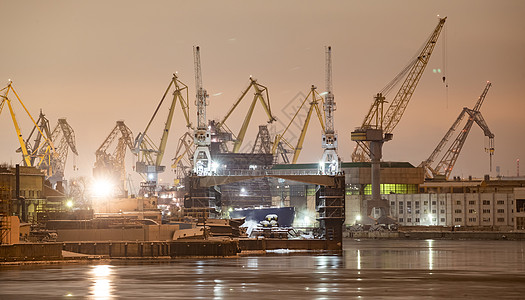 夜间建造核破冰器 冬季寒冷的波罗的海造船厂起重机 Neva河上蒸汽 河流平滑地表 雾雾后勤日落霜天码头出口破冰城市船厂贸易港口图片