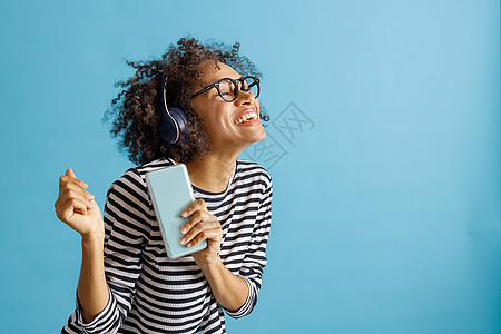 在智能手机上听音乐的开心女人图片