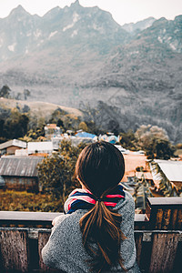 年轻女性的纵向后视镜 看着并享受美丽的山景风景游客运动旅游头发假期自由裙子远足顶峰悬崖图片