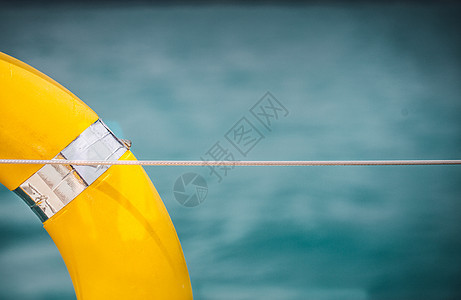 近身黄色生命环挂在有海洋背景的船上浮选生活橙子海滩绳索水池渡船救生圈安全帮助图片