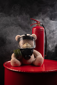 消防队的吉祥物是一只戴防毒面具的泰迪熊 背着黑暗背景烟雾中的灭火器灭火纪念品消防员红色火焰气体消防玩具安全创造力图片