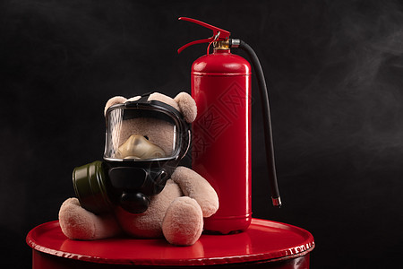 消防队的吉祥物是一只戴防毒面具的泰迪熊 背着黑暗背景烟雾中的灭火器面具消防火焰红色消防队员消防员风险灭火阴霾纪念品图片