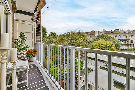 城市阳台俯视城市的阳台建筑椅子房子花卉建筑物天空露台花园木地板植物背景