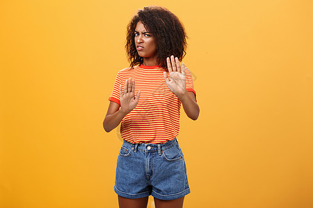 不 我拒绝 强烈怀疑和不满的聪明的非洲裔美国女性拒绝不好的提议 拉着举起的手掌 在橙色背景下带着厌恶和不满的表情转身离开女孩卷曲图片