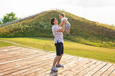快乐的孩子 爸爸和儿子玩得很开心 在阳光日落的背景下手牵着手 家庭 旅行 假期 童年 父亲节  概念闲暇父亲身份幸福福利太阳成人图片