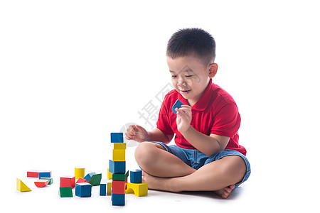 亚洲小男孩玩多彩街区游戏 孤立在白色背景上童年教育男生孩子活动地面幼儿园积木建筑乐趣图片