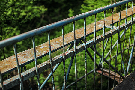 旧的金属警戒桥铁轨 背景中绿林模糊图片
