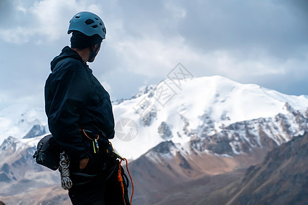 年轻人正在旅行 在山上徒步旅行旅游头盔绳索蓝色男人晴天探索假期运动登山图片