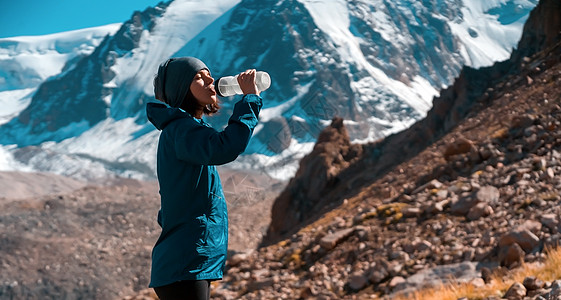 年轻女孩在山里喝水瓶子远足广告青菜跑步踪迹运动登山行星力量背景图片