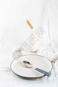 空盘子和勺子放在白布的桌子上 垂直视图( View)图片