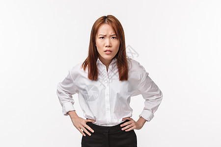 失望而严厉的亚洲女性的画像手握腰部向前弯腰 皱着眉头责怪 指责人不礼貌 责骂不听话的员工 白人背景背景图片