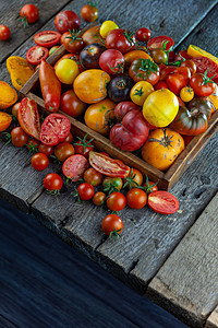 不同品种和颜色的西红柿顶视图 在一个木制的背景上的布局 食物 番茄片 沙拉配料 放置文本 黄色和红色的樱桃 复制空间图片