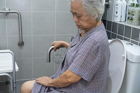 亚洲老年或老年老妇人病人在护理医院病房使用厕所浴室手柄安全 健康强大的医疗理念老年人酒店合金淋浴金属潮红汽车卫生间医院减值图片
